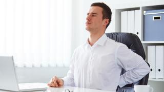 Mann benutzt Lordosekissen gegen Rückenschmerzen