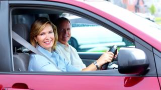 Frau und Mann sitzen im Auto auf einem Auto Sitzkissen
